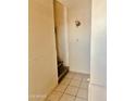 Hallway featuring tiled flooring, access to the stairs, and traditional wall decor at 4316 W Rose Ln, Glendale, AZ 85301