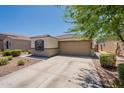 Inviting home exterior with a two-car garage, blue shutter, and drought-resistant landscaping at 7238 N 126Th Ln, Glendale, AZ 85307