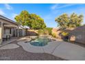 A refreshing backyard pool surrounded by lush greenery, a shed and patio furniture at 1415 W Michigan Ave, Phoenix, AZ 85023