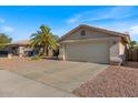 A single-story home featuring a two-car garage and desert landscaping for low maintenance at 1415 W Michigan Ave, Phoenix, AZ 85023