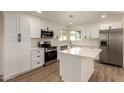 Bright kitchen with white cabinetry, stainless steel appliances, quartz countertops, and a kitchen island at 1521 W Jacinto Ave, Mesa, AZ 85202