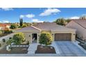 Lovely single-story home with a tile roof, green landscaping, and a two-car garage under a blue sky at 1673 E Laddoos Ave, Queen Creek, AZ 85140