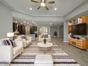 Bright open concept living room with high ceilings, modern furnishings, and an adjacent open-plan kitchen at 18389 W Long Lake Rd, Goodyear, AZ 85338