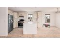 Newly renovated kitchen boasts stainless appliances, white cabinetry, and a functional island at 201 S 91St St, Mesa, AZ 85208