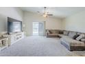 Bright living room featuring neutral carpet, a ceiling fan, and a large sectional sofa at 2717 W Bowker St, Phoenix, AZ 85041