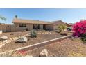 Single-story home featuring desert landscaping with natural rocks and blooming shrubs at 3529 W Saint Moritz Ln, Phoenix, AZ 85053