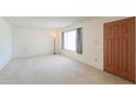 The empty living room features carpet floors and natural light from a window at 5800 S College Ave, Tempe, AZ 85283