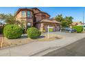 Charming two-story home with a three-car garage, beautiful landscaping, and green shrubs at 7246 W Monte Cristo Ave, Peoria, AZ 85382