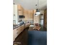 Modern kitchen featuring sleek black countertops, pendant lighting and wooden cabinets and backsplash at 9894 N 79Th Pl, Scottsdale, AZ 85258