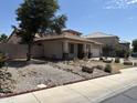 Side view of a well-maintained home, complimented by desert landscaping and privacy at 9911 W Riverside Ave, Tolleson, AZ 85353