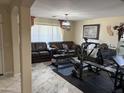 Open living room with neutral paint, with a fitness center. A perfect blend of comfort and convenience at 9911 W Riverside Ave, Tolleson, AZ 85353