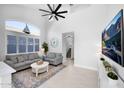 Bright living room with soaring ceilings, large windows, a ceiling fan, and cozy furniture at 9918 E Escondido Ave, Mesa, AZ 85208