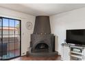 Cozy living room with a rustic fireplace, entertainment center, and a sliding glass door to the patio at 10410 N Cave Creek Rd # 2229, Phoenix, AZ 85020