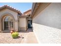 Inviting front entrance with a decorative door, arched window, and well-maintained desert landscaping at 15953 W Catalina Dr, Goodyear, AZ 85395