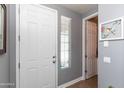 Bright entryway featuring a white door, gray walls, and decorative accents for a clean, modern look at 19461 N Rose Rd, Maricopa, AZ 85138