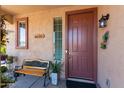 Welcoming front porch with a wooden bench, potted plants, and decorative touches by the entrance at 19461 N Rose Rd, Maricopa, AZ 85138