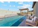 Stunning pool area with lounge chairs, decorative wall, and a covered patio for relaxing by the water at 25876 N 162Nd Dr, Surprise, AZ 85387