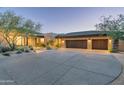 Beautiful exterior of custom home with stone accents, desert landscaping, and an extended driveway at 39089 N 102Nd Way, Scottsdale, AZ 85262