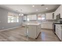Bright kitchen featuring white cabinets, an island, modern appliances, and wood floors at 408 W Sweet Shrub Ave, San Tan Valley, AZ 85140