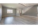 Spacious living room with wood floors, neutral paint, modern chandelier, and staircase at 408 W Sweet Shrub Ave, San Tan Valley, AZ 85140