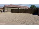 Fully enclosed backyard with desert rock landscaping and a tall privacy wall at 42087 W Manderas Ln, Maricopa, AZ 85138