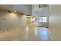 Spacious living room featuring hardwood floors and kitchen area with a window at 4776 W Eva St, Glendale, AZ 85302