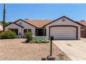 Charming home with desert landscaping, a two-car garage, and a welcoming entrance at 10807 W Morten Ave, Glendale, AZ 85307