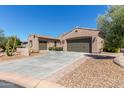 View of the home's driveway, multiple garages, and desert landscaping at 12710 W Forest Pleasant Pl, Peoria, AZ 85383