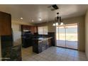 Modern kitchen featuring an island, dark countertops, tile floors, and sliding glass doors to yard at 1414 W Monona Dr, Phoenix, AZ 85027