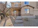 Inviting front entrance with a stone accent wall and brick walkway at 15611 W Cameron Dr, Surprise, AZ 85379