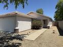 Welcoming single-level home featuring a two-car garage, desert landscaping and a cozy entryway at 15706 W Young St, Surprise, AZ 85374