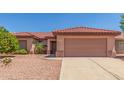 Inviting single-level home with a two-car garage, desert landscaping and clay tile roof at 15980 W Quail Creek Ln, Surprise, AZ 85374
