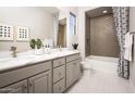 Bright bathroom with double sinks, quartz countertops, patterned tile in the shower and stylish fixtures at 22673 E San Tan Blvd, Queen Creek, AZ 85142