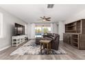 Inviting living room featuring wood floors, a ceiling fan and sliding glass doors to the backyard at 40913 W Williams Way, Maricopa, AZ 85138