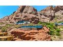 Striking desert home with glass walls and stone accents, set against a dramatic red rock mountain backdrop at 4925 E Red Rock Dr # 43, Phoenix, AZ 85018