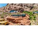 Contemporary house features glass walls and stonework blending seamlessly with the rugged red rock terrain at 4925 E Red Rock Dr # 43, Phoenix, AZ 85018