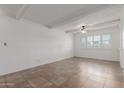 Bright, airy living room with tiled floors, white brick accent wall and a ceiling fan at 8211 E Garfield St # J219, Scottsdale, AZ 85257