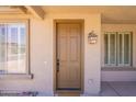 Close-up of the front door with a stylish lantern and sidelight windows at 888 S 165Th Ln, Goodyear, AZ 85338