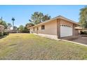 Exterior view of a home with a private side yard and a two-car garage at 10205 W Royal Oak Rd, Sun City, AZ 85351
