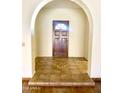 Inviting entryway with a decorative tile landing and a dark wood door with a decorative window at 1249 E Commerce Ave, Gilbert, AZ 85234