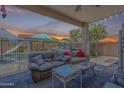 Outdoor patio area with comfortable seating overlooking a private backyard and sparkling pool at 16136 W Durango St, Goodyear, AZ 85338