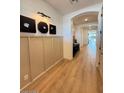 Modern home hallway with decorative wall trim, wood floors, and an arched doorway leading to bright living spaces at 18747 W Monterosa St, Litchfield Park, AZ 85340