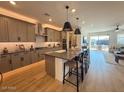 Stylish kitchen boasts a spacious island with bar stools, modern pendant lighting, and stainless steel appliances at 18747 W Monterosa St, Litchfield Park, AZ 85340