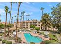 A refreshing community pool featuring comfortable lounge chairs, umbrellas, and lush landscaping at 19400 N Westbrook Pkwy # 220, Peoria, AZ 85382