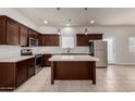 Modern kitchen with stainless appliances, dark wood cabinets, and a center island at 2000 N 36Th St # 10, Phoenix, AZ 85008