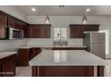 Modern kitchen featuring dark wood cabinets, stainless steel appliances, quartz countertops, and pendant lighting at 2000 N 36Th St # 41, Phoenix, AZ 85008
