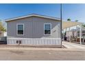 Charming single-story home with gray siding and carport in a sunny community at 2060 N Center St # 133, Mesa, AZ 85201