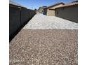 Spacious side yard features decorative rocks for low maintenance and leads to the backyard at 22325 N 185Th Ave, Surprise, AZ 85387