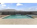 Backyard view showcasing a refreshing pool and spa surrounded by a low-maintenance desert landscape at 22657 N 184Th Ln, Surprise, AZ 85387