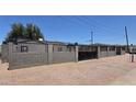 Exterior view of the home featuring a fenced yard with gate and desert landscaping at 404 E Centre Ave, Buckeye, AZ 85326